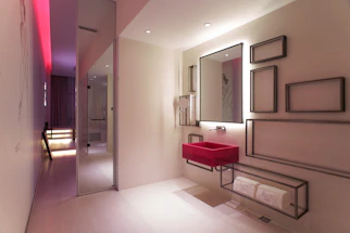 A sleek modern bathroom sink area with soft blue accent lighting.