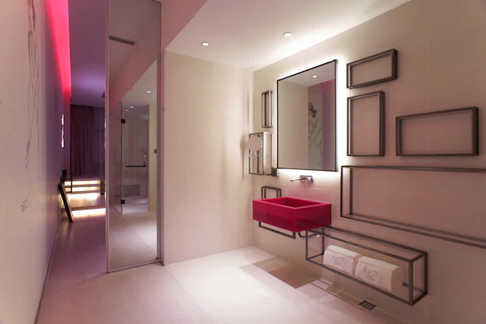 A sleek black and red neon-lit basin with glowing edges in a futuristic bathroom setting.