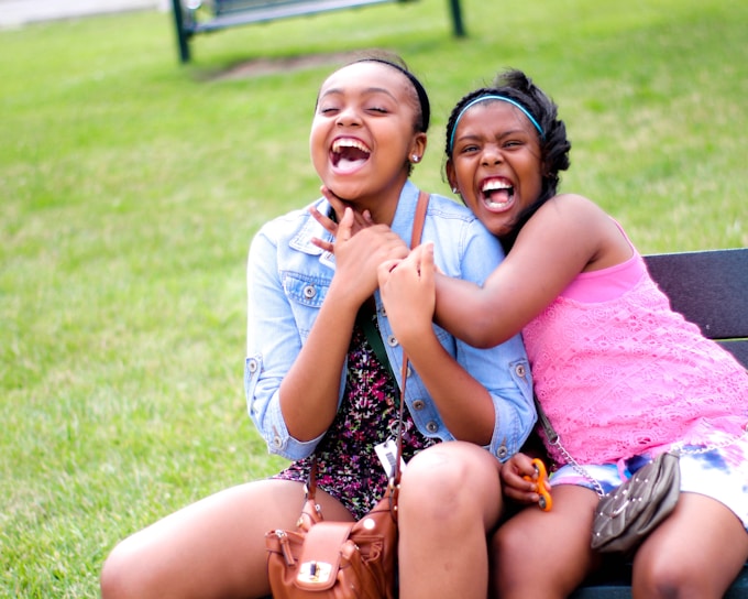 A joyful moment of two girls playing together in a sunny park.