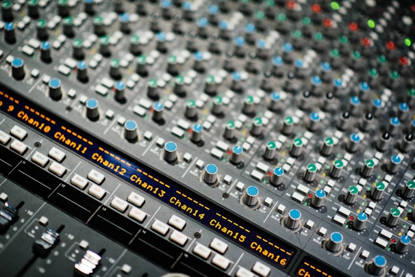 Close-up of an advanced audio mixing console with multiple channels set up for a live church broadcast.