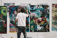 man wearing white shirt painting a wall