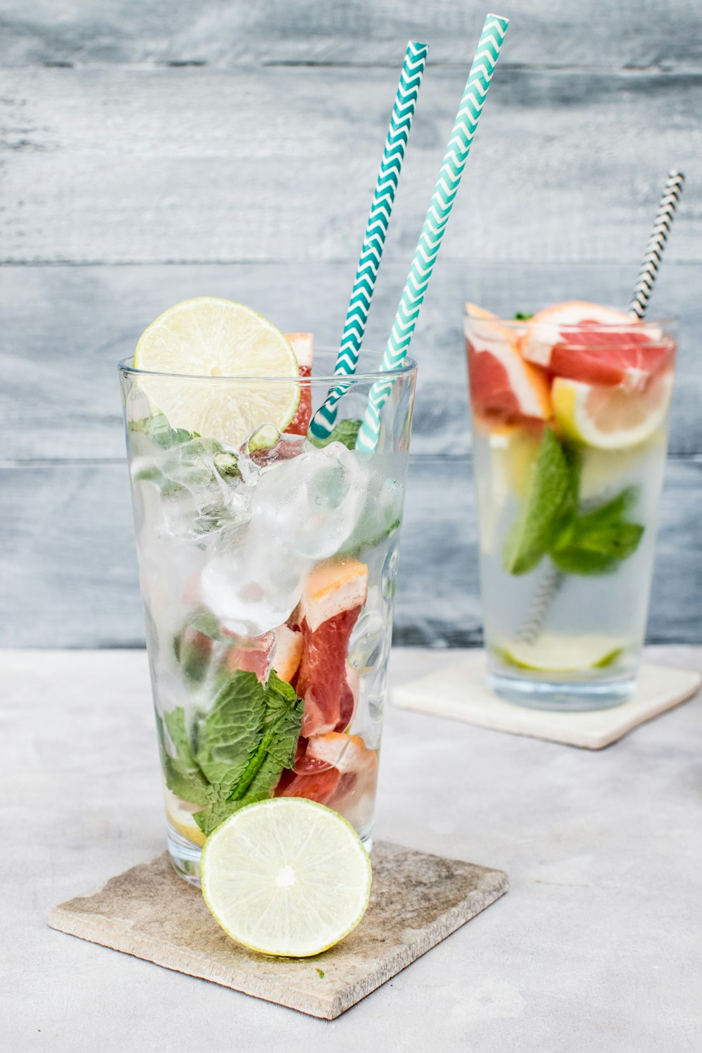 two filled drinking glasses with beverages