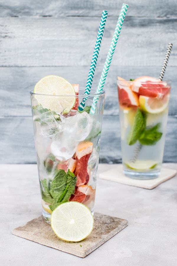Two filled drinking glasses with beverages