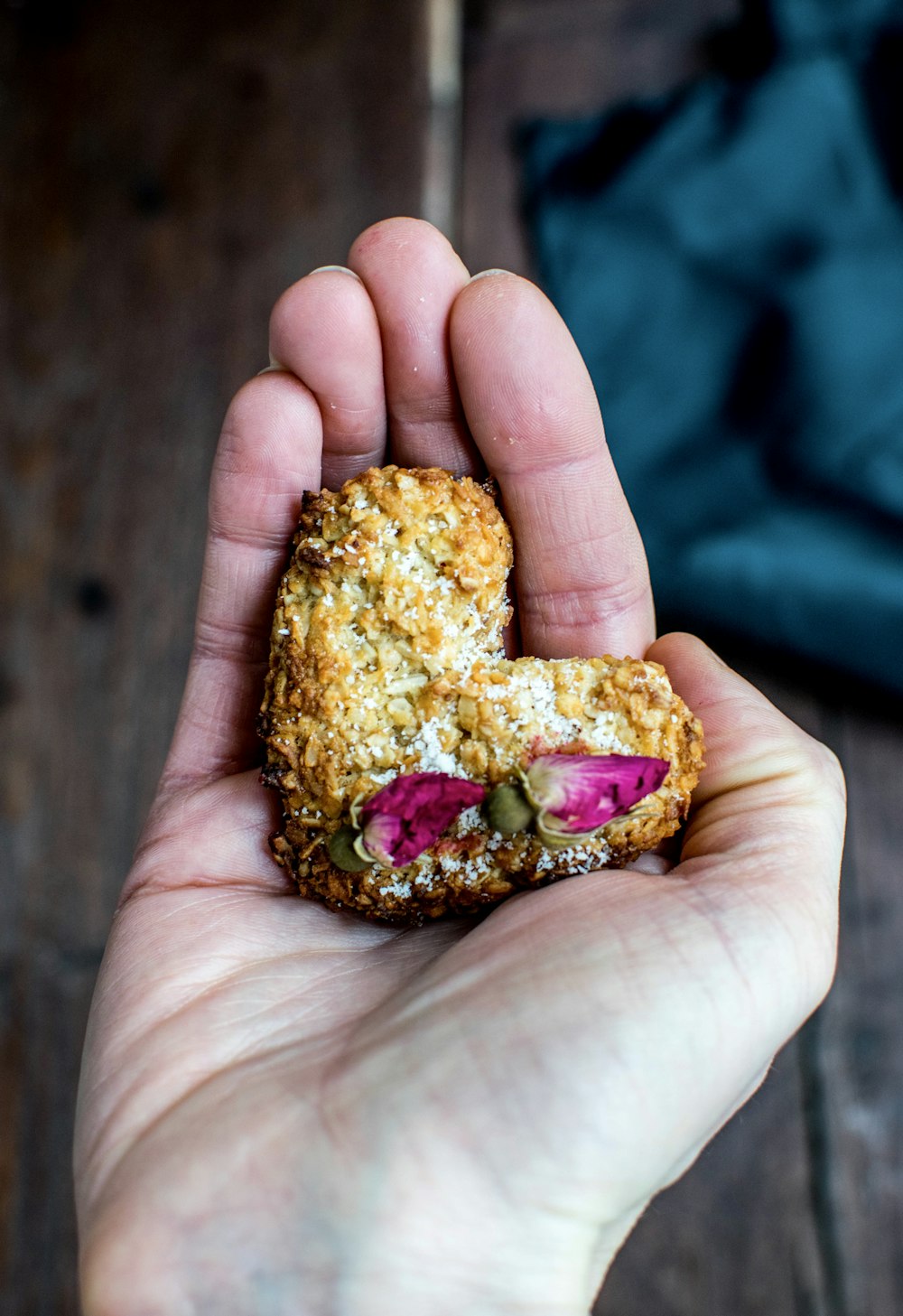 a person holding a heart shaped biscuit in their hand