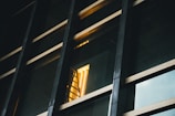 Abstract shot of layered glass panels reflecting warm gold light on a white surface.
