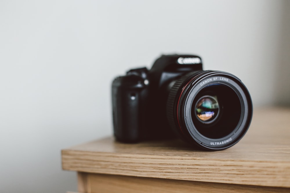 selective focus photo of black Canon DSLR camera on table