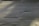 Corrugated metal sheets are aligned vertically with visible screws and a central seam. The surface appears weathered with some discoloration and shadows cast across it.