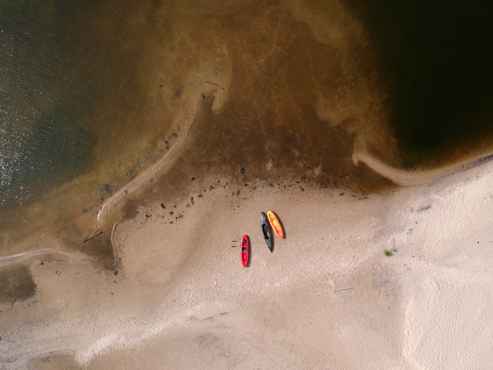 Fotografía aérea de tres kayaks cerca de un cuerpo de agua