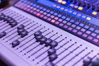 Mix engineer focused on multiple monitors with sound levels visible