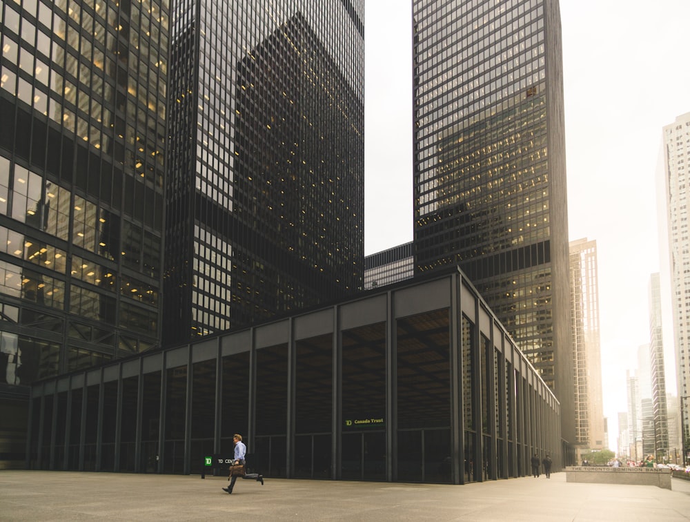 man walking along high-rise building