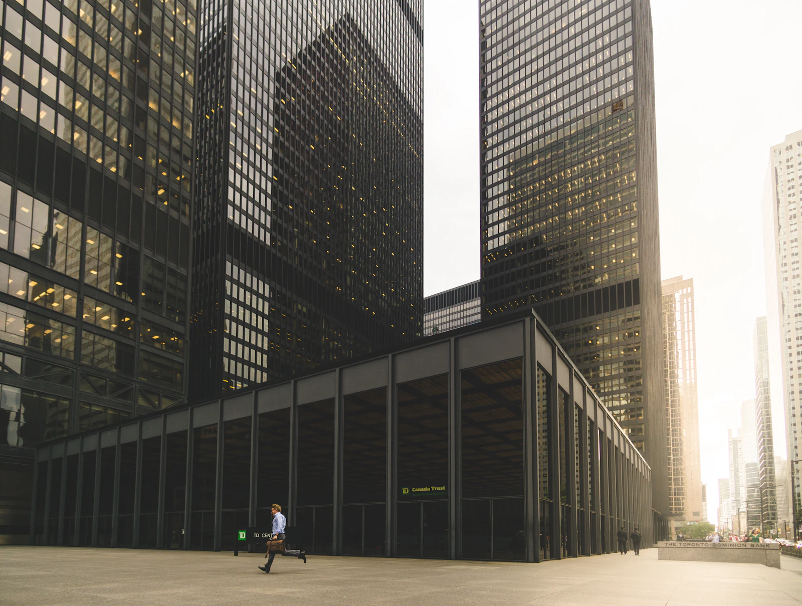 Figure walking beside a high-rise elevation
