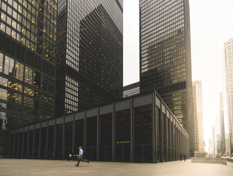 Figure walking beside a high-rise elevation