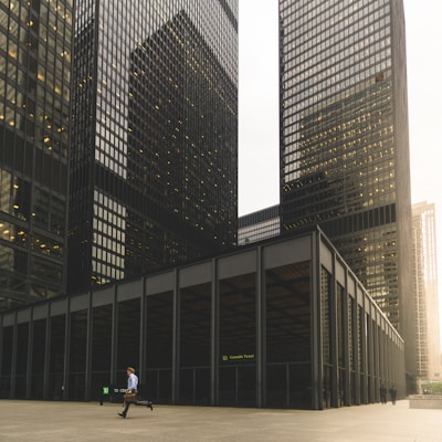 man walking along high-rise building