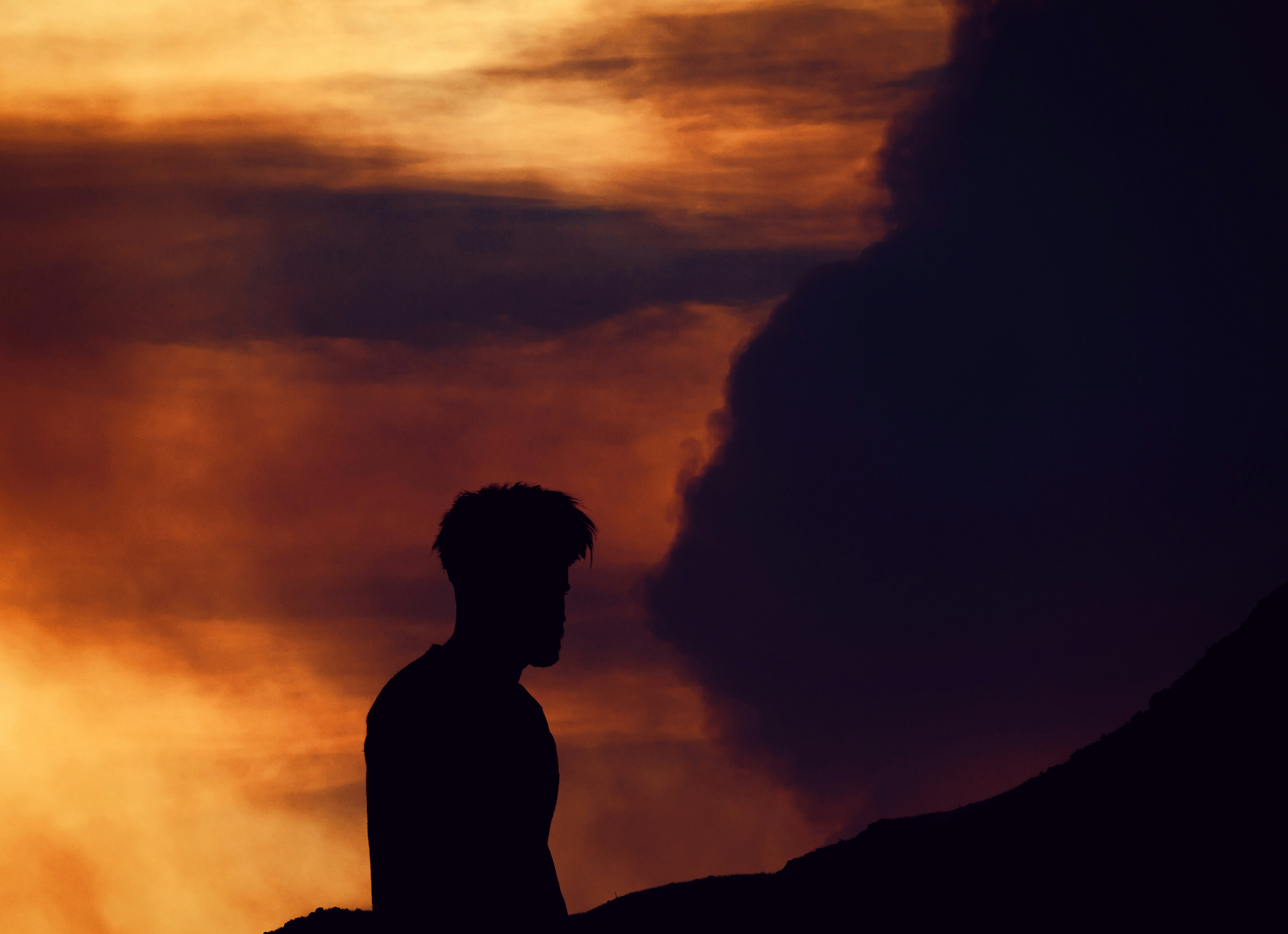silhouette photo of man near body of water