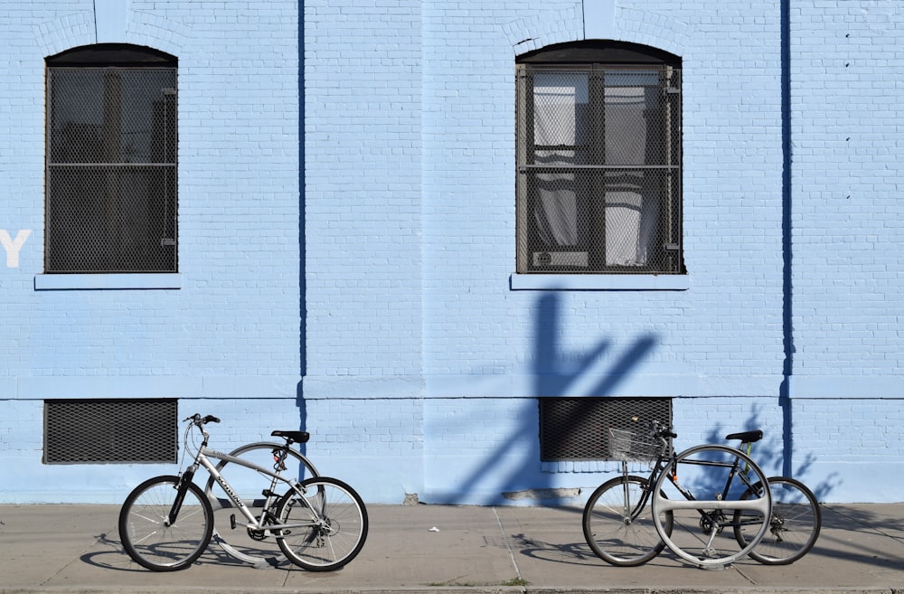 파란 건물 앞에 자전거 2대 주차