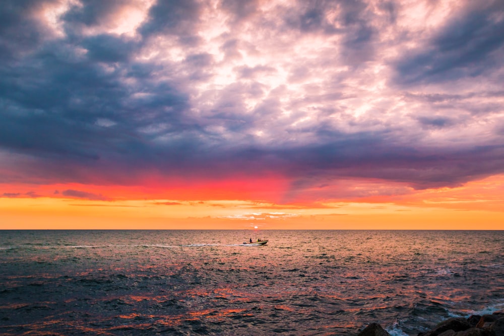 bateau sur la mer au coucher du soleil