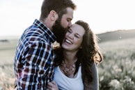 man kissing woman in grass area