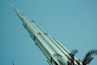 A sleek architectural rendering of Max Palace hotel rising against a clear Florida sky.