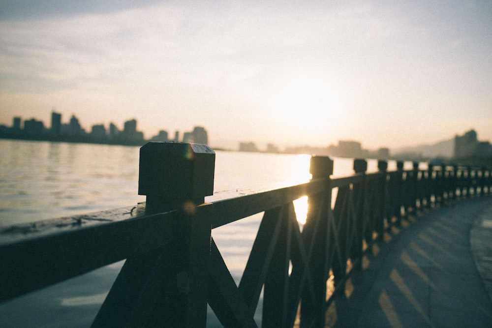 brown wooden dock railings with body of water background