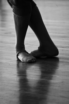 Close-up of hands and feet moving fluidly on a wooden floor.