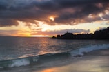 Sunset over a Pismo Beach oceanfront property with waves crashing nearby.