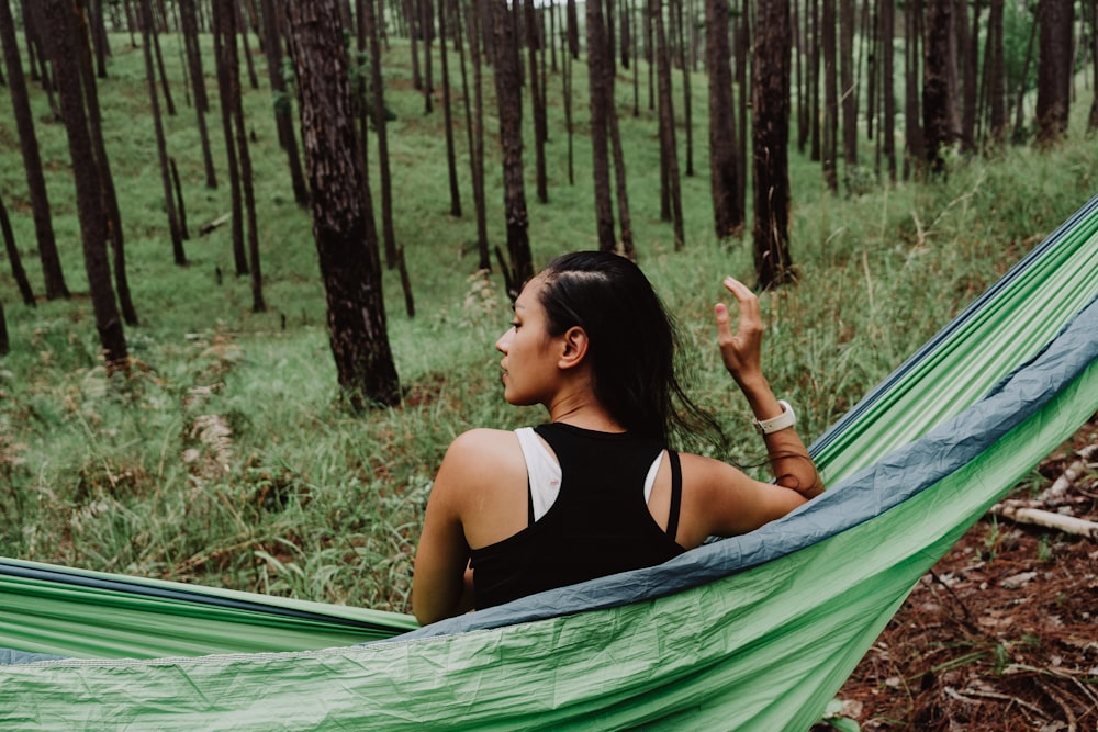 woman in black sport tank top seating on hammock