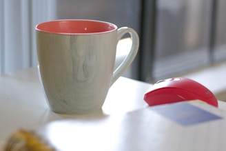 A close-up of a vibrant custom-printed mug and mousepad on a clean white desk with blue accents.