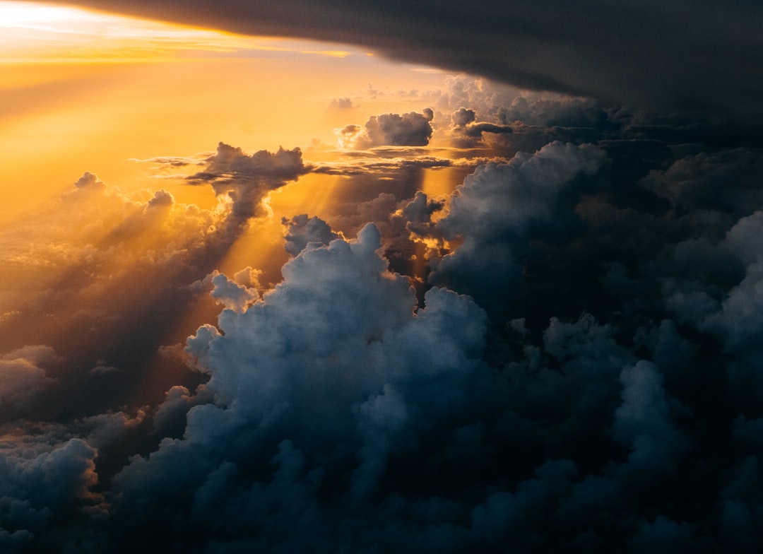 sunlight through clouds photography, This picture is taken as our plane passed through a thunderstorm. The sunset was ti