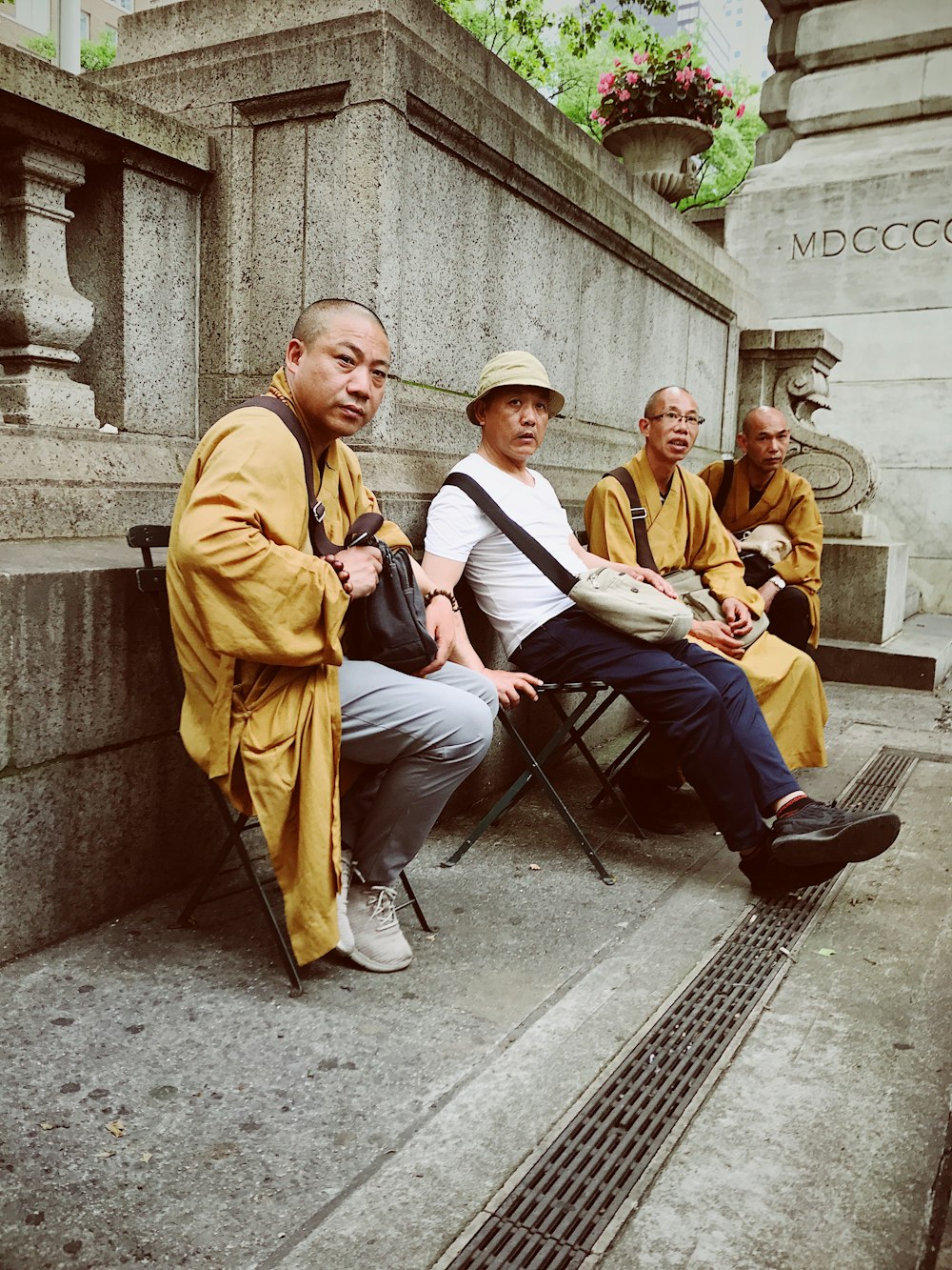 four men sitting on chairs outdoor during daytime