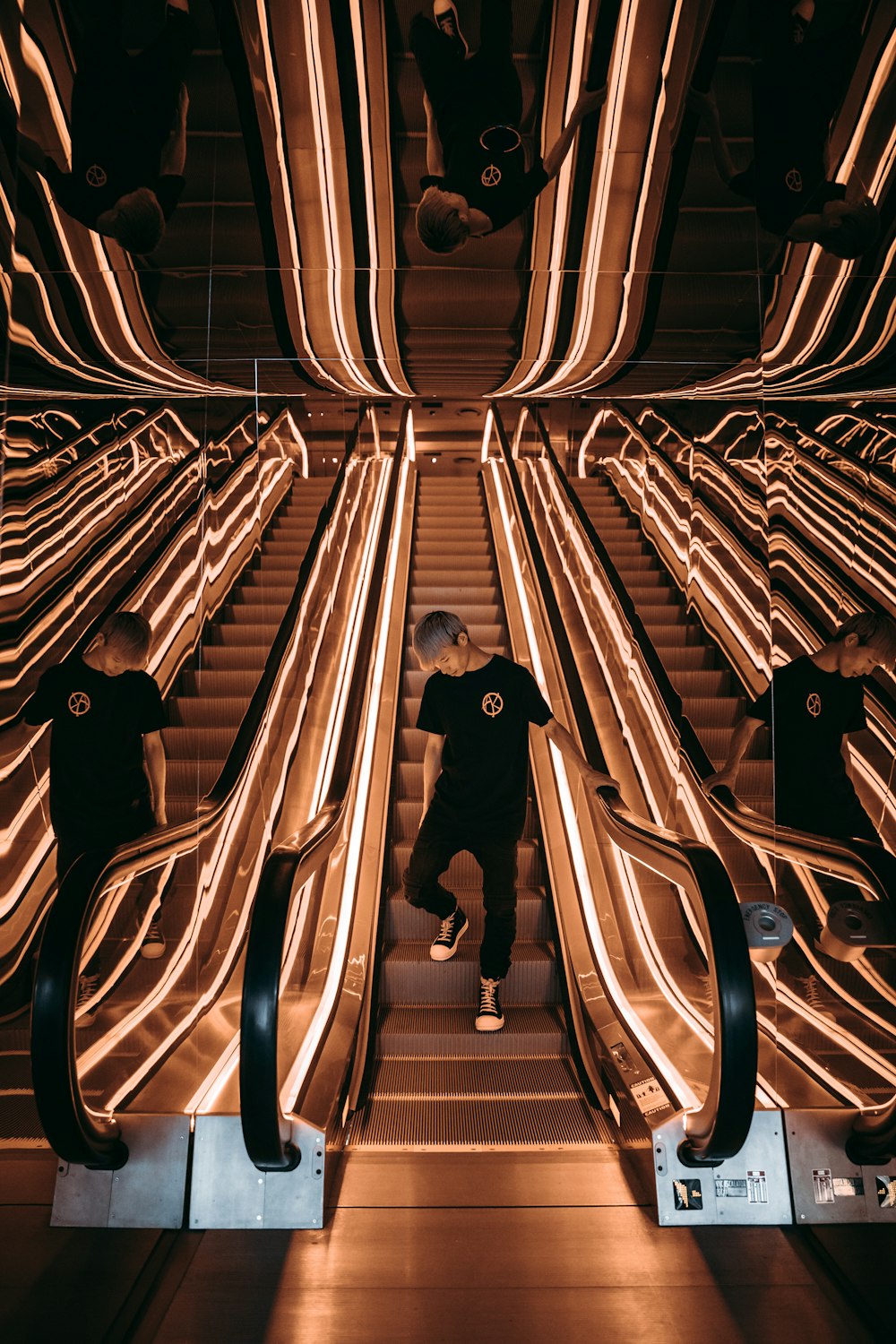 man standing on escalator with string lights