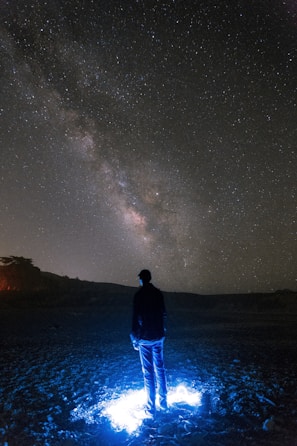 An atmospheric drawing of a lone traveler under a starry sky