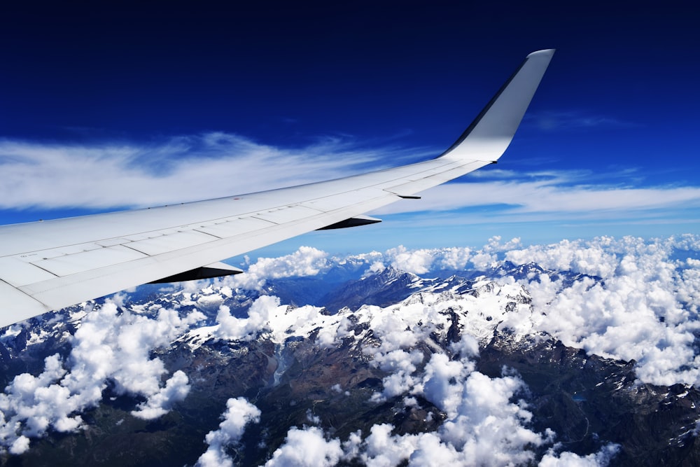 the wing of an airplane flying over a mountain range