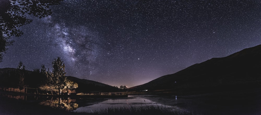 Reflektierende Fotografie eines beleuchteten Hauses in der Nähe eines Gewässers