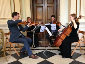 A string quartet performing elegantly at a luxurious wedding reception with deep blue and gold decor.