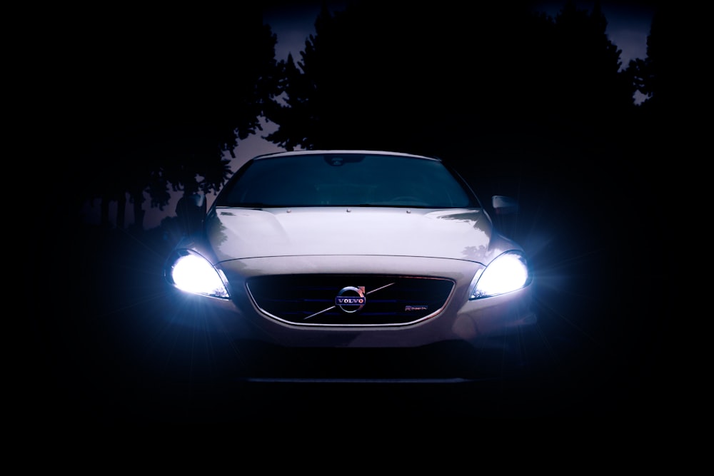 silver Volvo car with headlights on during night