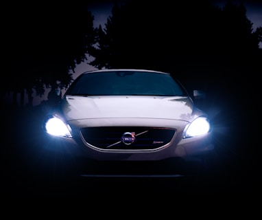 silver Volvo car with headlights on during night