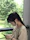 Young woman standing outdoors, checking her phone while walking on campus