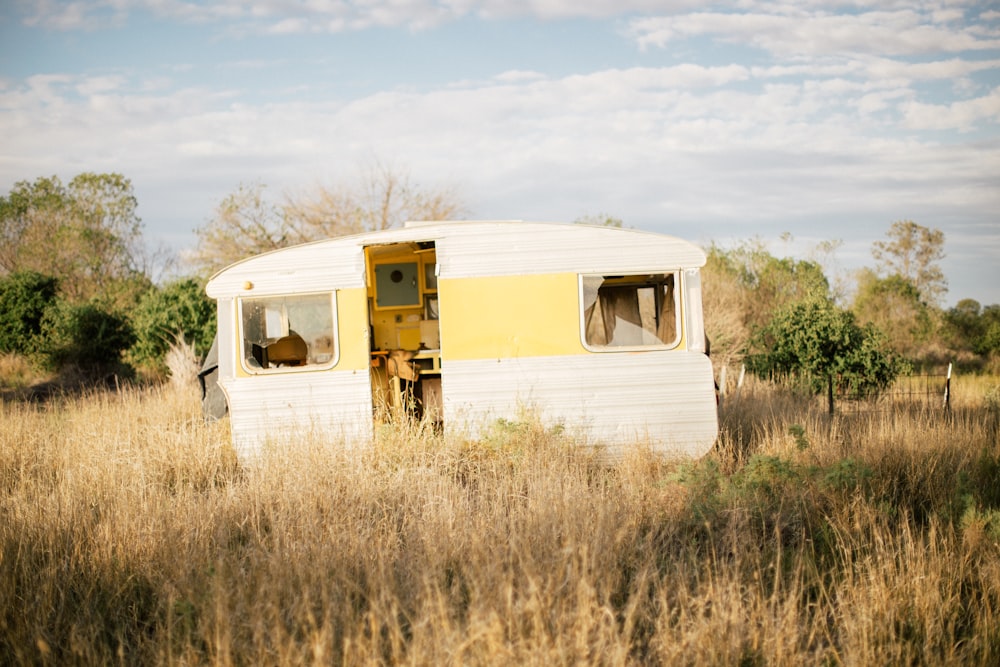 white RV trailer in the middle of grass field