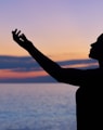 silhouette of woman raising her right hand