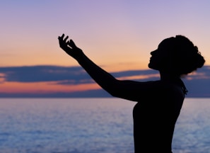 silhouette of woman raising her right hand