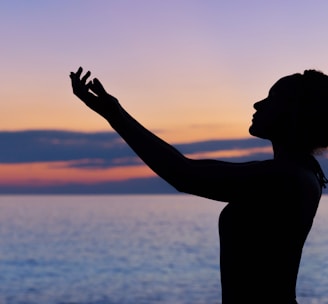 silhouette of woman raising her right hand