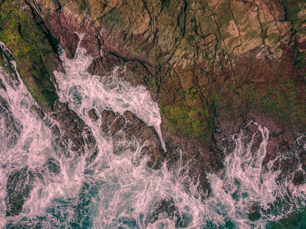 Selektives Foto des braunen Berges neben einem Gewässer bei Tag