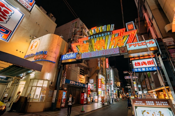 A nighttime view of a shopping district filled with colorful signage.