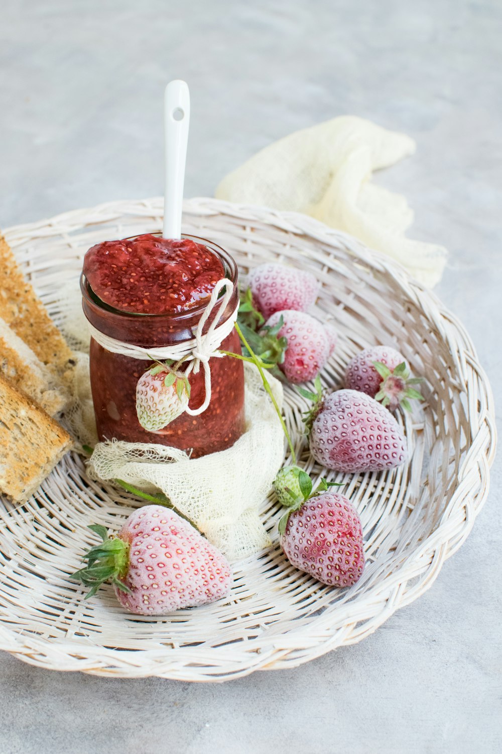 basket of strawberry fruits with jar of jam