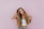 woman standing next to pink wall while scratching her head