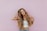 woman standing next to pink wall while scratching her head