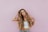 woman standing next to pink wall while scratching her head