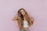 woman standing next to pink wall while scratching her head