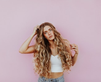 woman standing next to pink wall while scratching her head