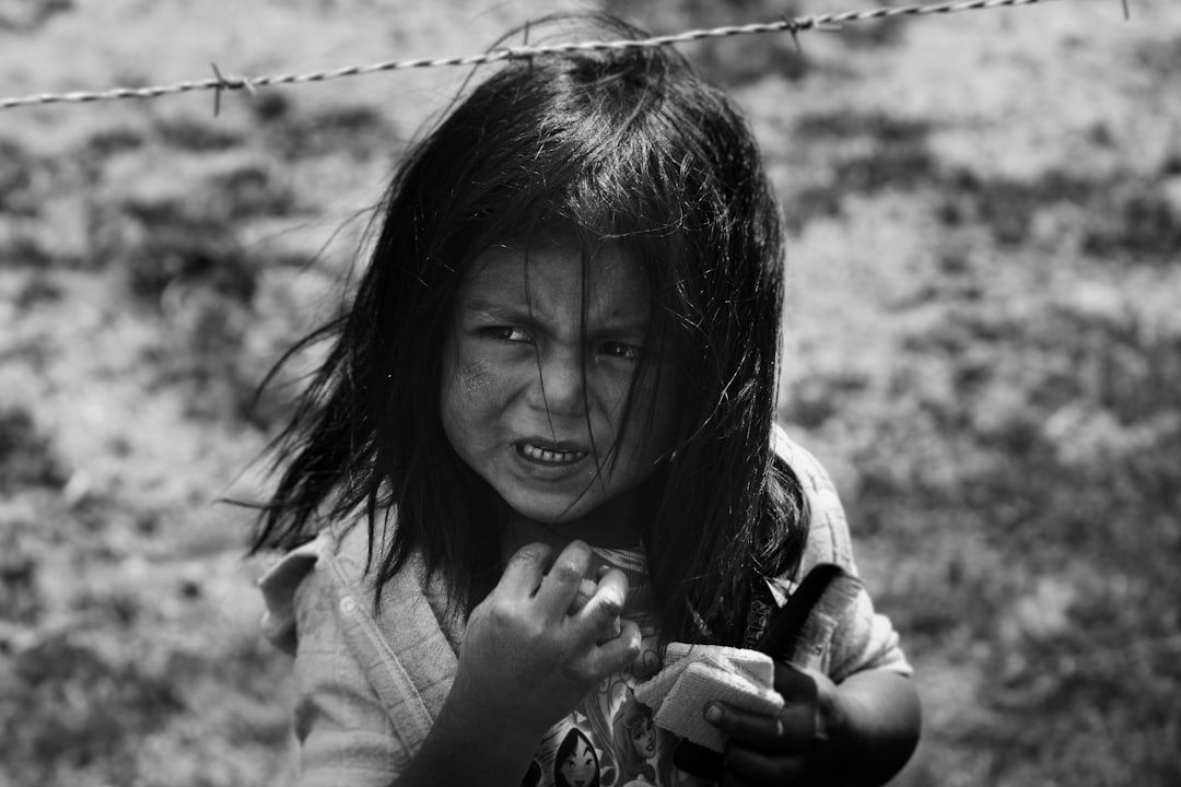 girl holding hair comb behind barbed wire